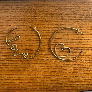 Noonday Collection gold colored “love” hoop earrings.